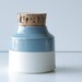 medium blue and white porcelain bottle. corked container. spice jar
