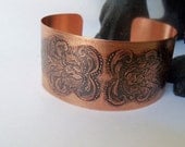 Copper cuff bracelet created from sheet metal and etched with a floral design
