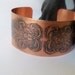 Copper cuff bracelet created from sheet metal and etched with a floral design