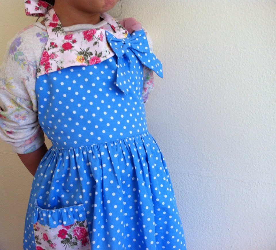 Girl apron, white polka dots on a blue fabric.