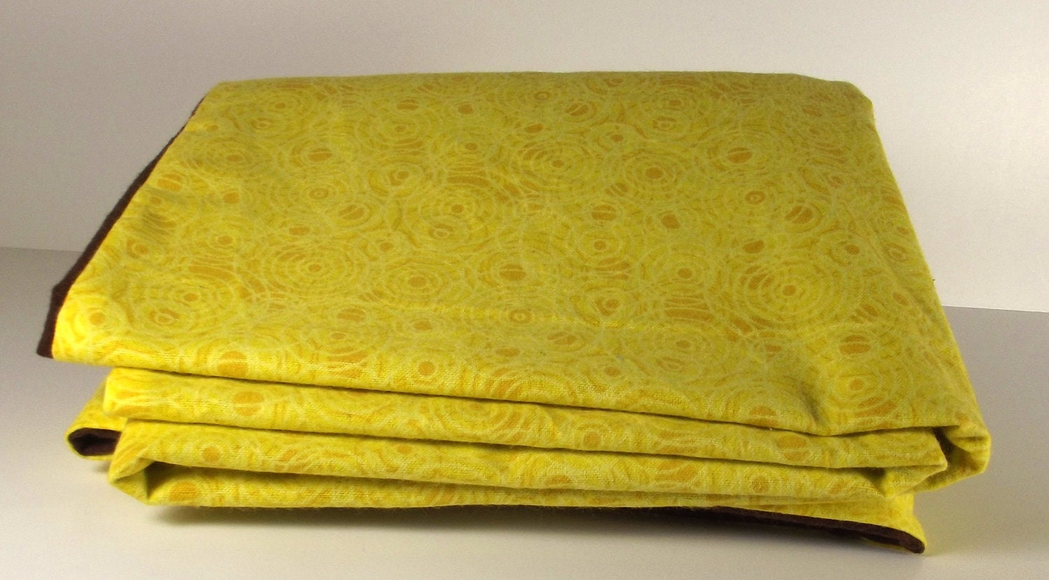 large baby blanket double sided yellow swirl  motif, soft cozy chocolate brown on back