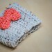 crochet coffee cozy sleeve in oat with cute coral bow.