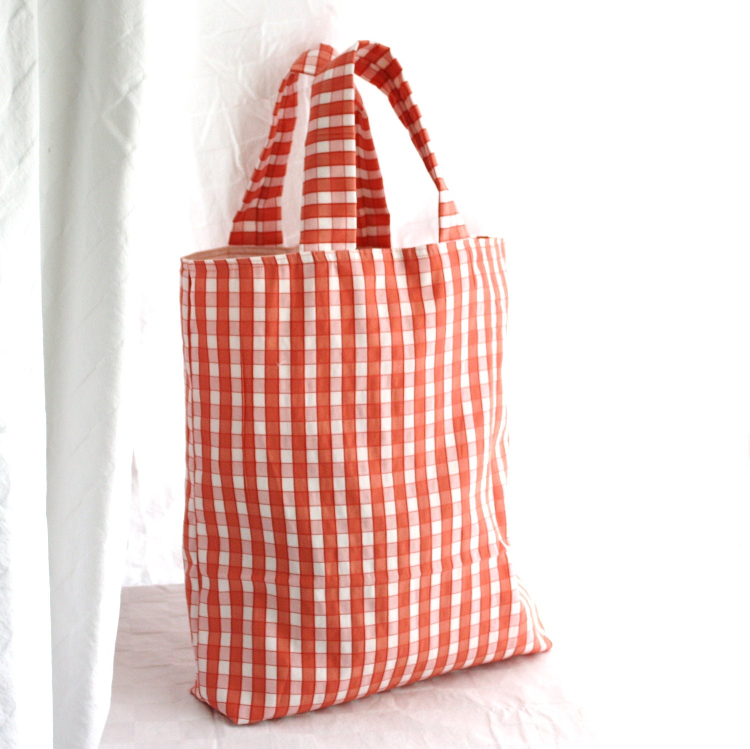 Oversized large market tote bag in pink and coral check plaid with pink interior. Inside pockets and snap closure.