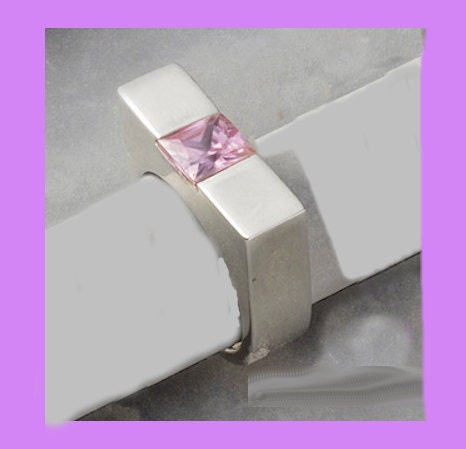 An ErgonomicSterling Ring with pink CZ.