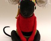 Woollen mouse dressed in yellow hat with bell and flowers.