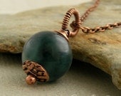 Green jade pendant on chain with antiqued copper beadcap and wire wrapped bail