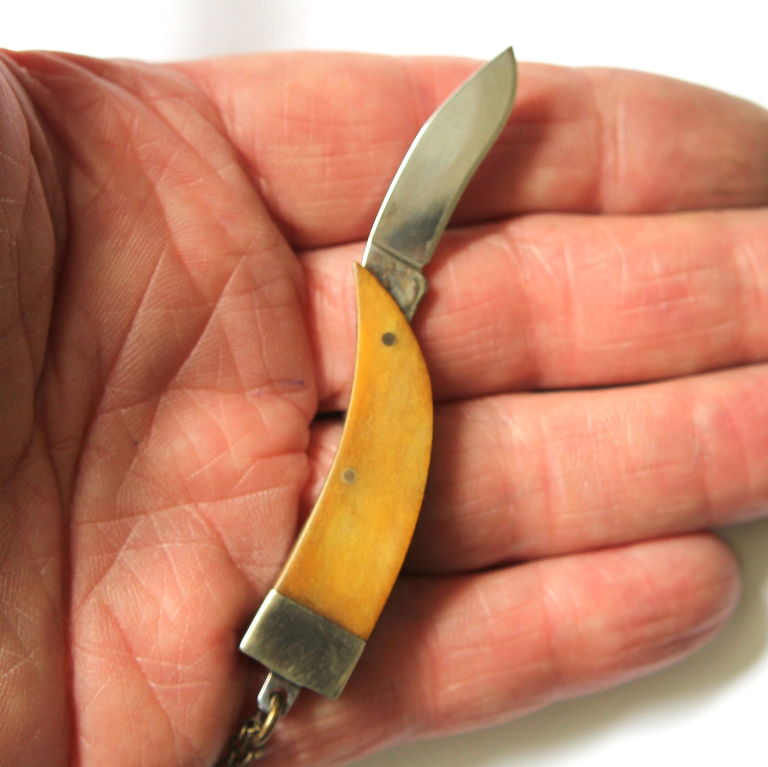 Genuine Amber Bone Claw Pendant Necklace with a Hidden Folding Knife Blade
