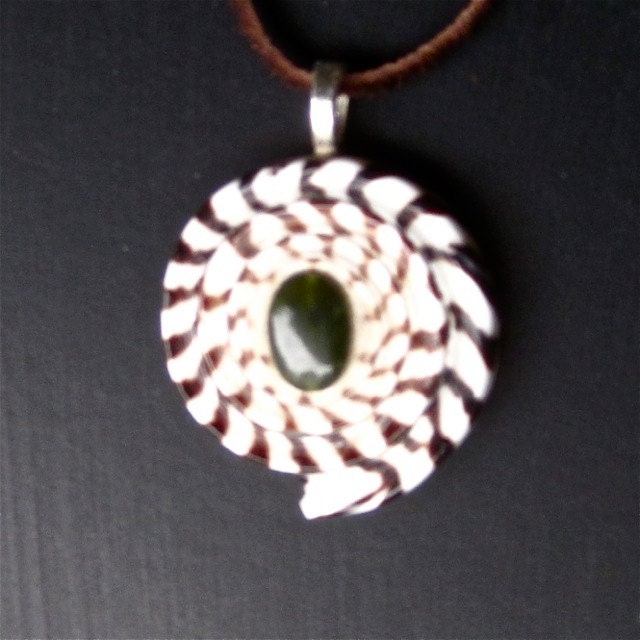 Seashell pendant with an inlaid gemstone