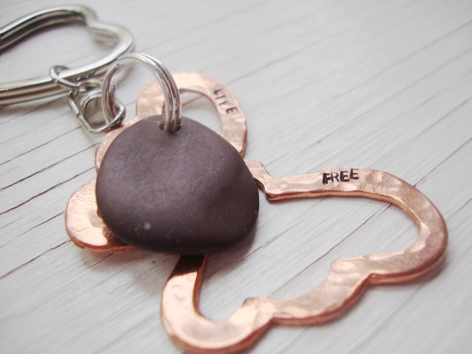 live free open copper butterfly keychain with smooth brown beach stone