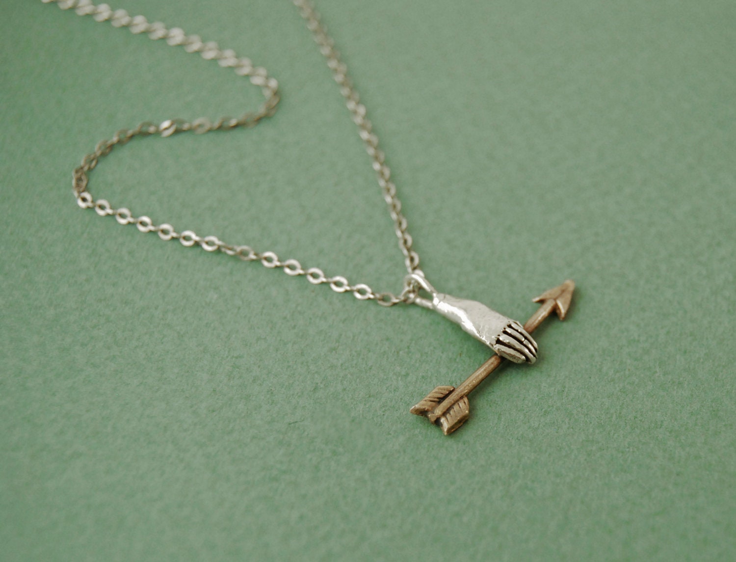 Hand with golden arrow necklace