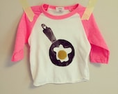 Sunny side up egg on a neon pink raglan