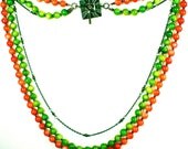 Tangerine, lime, and antiqued brass three strand beaded necklace with antiqued brass toggle.