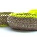 A set of three natural cotton crocheted jewellery baskets, with contrasting bright neon thread