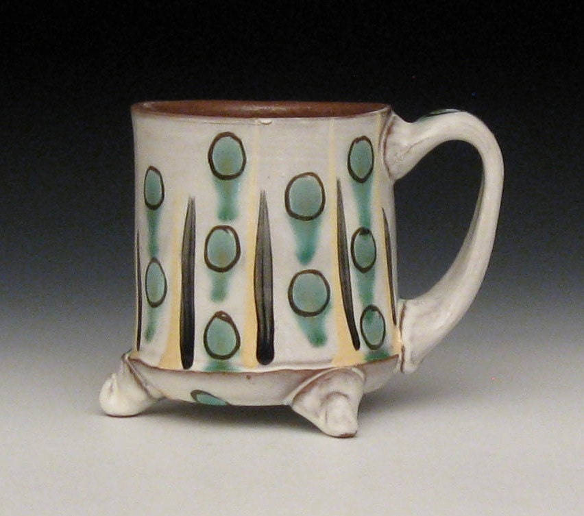 yellow and black striped mug with copper green dots and feet