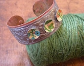 Vintage steel and reclaimed tins, patinaed copper cuff. Woodland flowers.