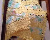 Yellow crocheted stork baby picnic blanket. 