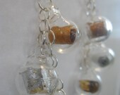 3 bubble earrings,  each with small scrolls of metal foil inside. One silver, one copper, one gold.
