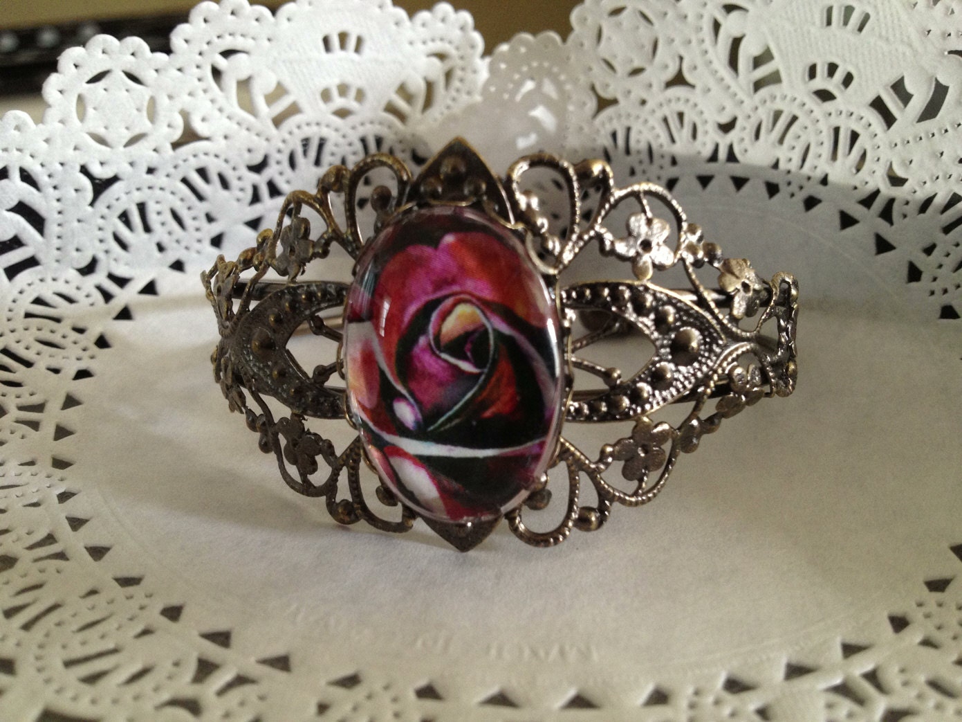 1 beautiful Filigree Bracelet with rose 18 x 25 mm image on the pad. This is a bracelet made of copper and bronze plated.