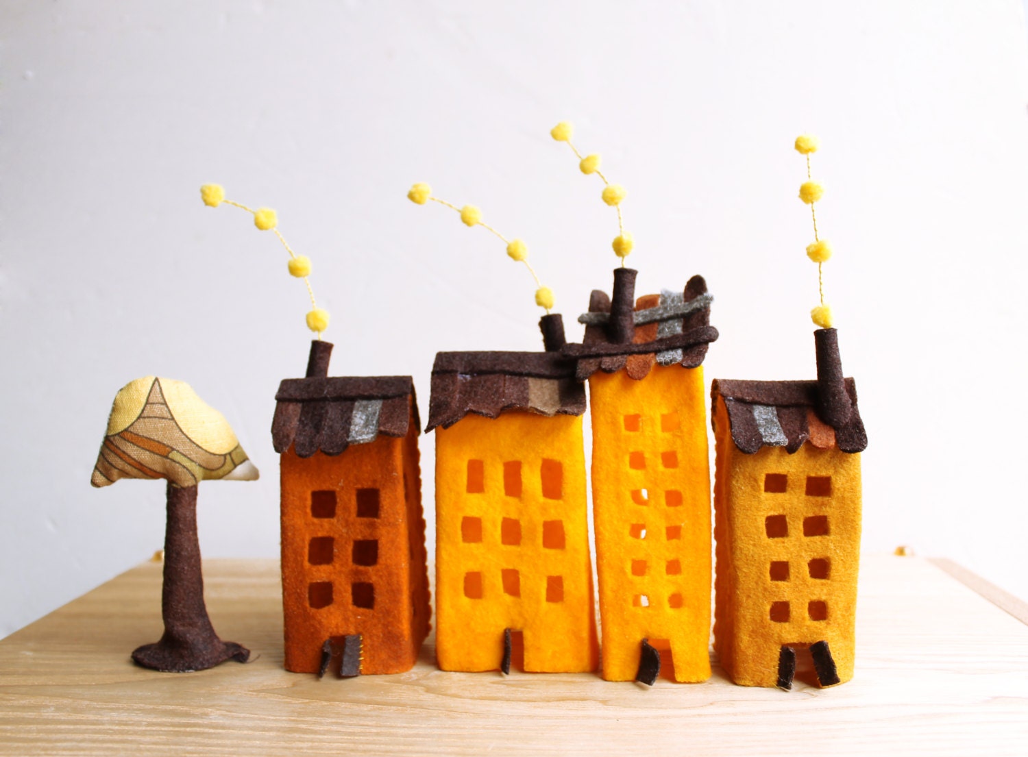 Four buildings of felt, with a tree. Miniature. Decoration.