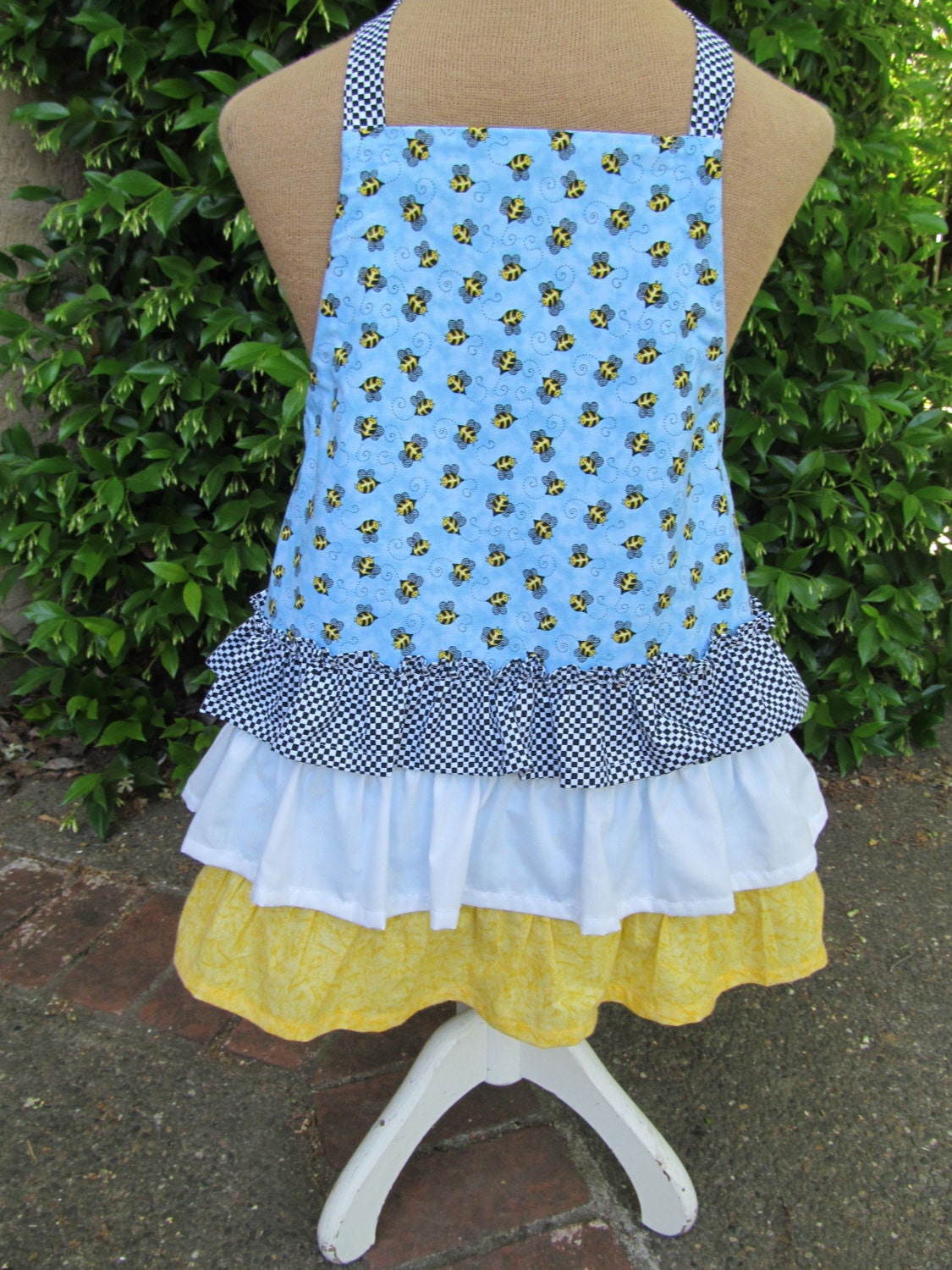 Handmade child's bumble bee print apron with three ruffles