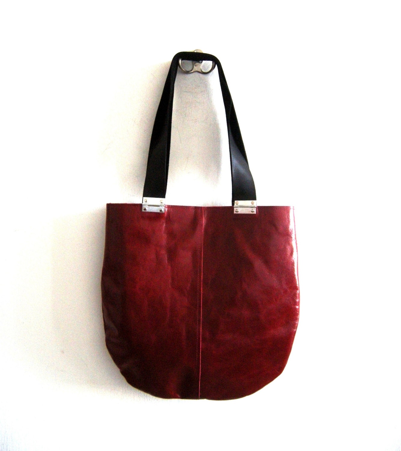 Red leather bag with black strips and hinges