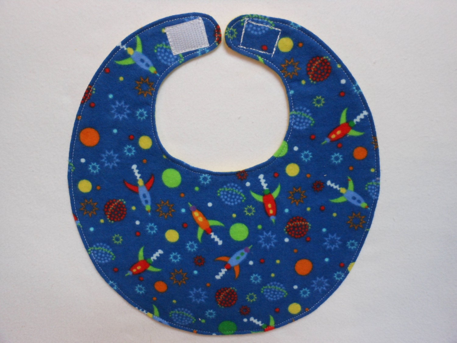 Baby bib, four soft layers, reversible, blue with bright little spaceships