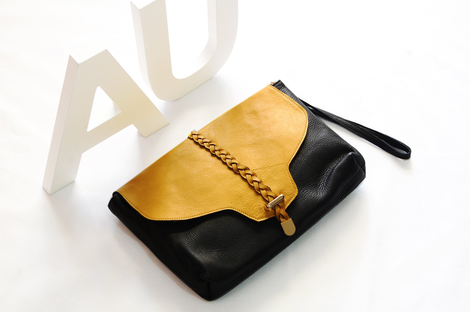 20% off black leather clutch with deep yellow leather braid