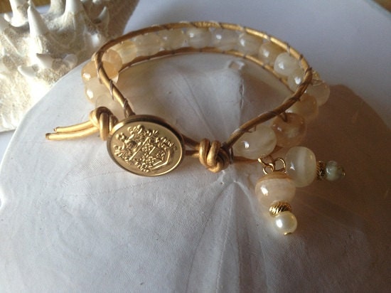 8 1/2" semi-precious bead ladder bracelet with gold pearl finish leather cord, dangle charms and gold tone vintage button closure.