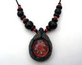Millefiori tribal pattern pendant made from polymer clay and glass, bright red and black, with acai beads on thin adjustable cord, handmade