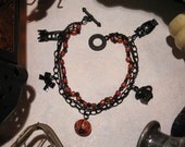 The Call Came From Inside The House charm bracelet in black enameled base metal and glass horror movie babysitter Halloween slasher lampwork