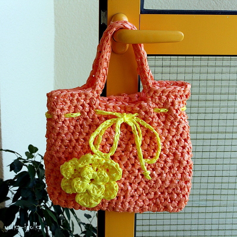 Orange bag crocheted with yellow flower.