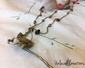 tierra. a long feather, tigers eye, and thread bobby pin