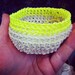 A set of three natural cotton crocheted jewellery baskets, with contrasting bright neon thread