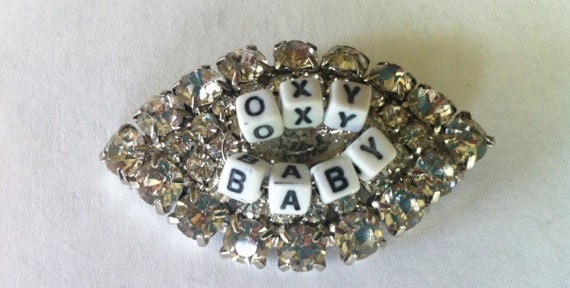 Vintage Sixties Eye-Shaped Rhinestone Crystal Pin with "Oxy Baby" Words