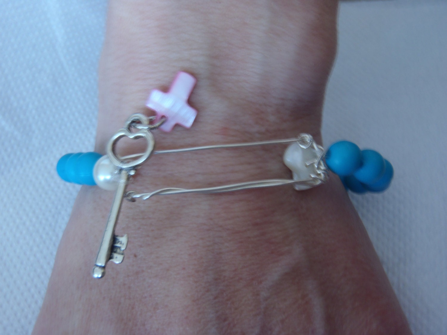 Classic and Modern Blue Bracelet with blue beads, silver key charm as clip, pink cross, white shell and genuine pearl