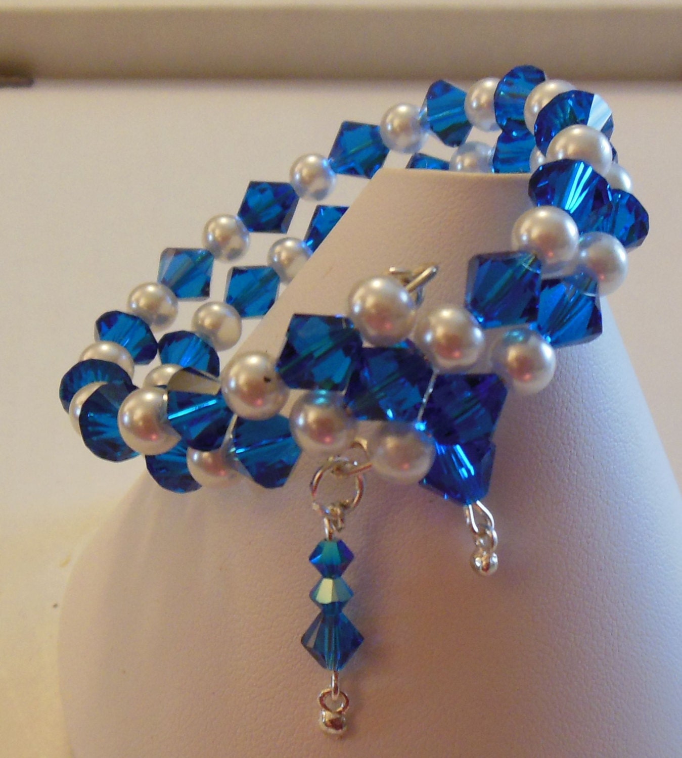 bb817 - Swarovski Capri Blue various sizes bicone and white glass pearls, charms, memory wire bracelet