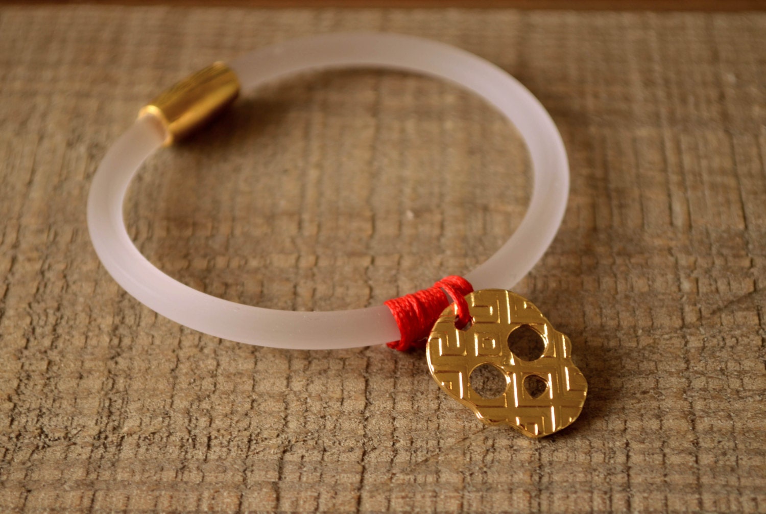 Gold skull bracelet, white transparent rubber cord