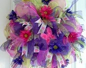 Spring Deco Mesh Wreath with purple and lime green mesh, glitter daisies ribbon, pink butterfly, daisies, streamers and pink flowers.