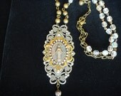 Vintage Jewelry,Religious Jewelry with Virgin Mary. Brass tone center surrounded by rhinestones. Crystal and brass rosary beads on necklace.
