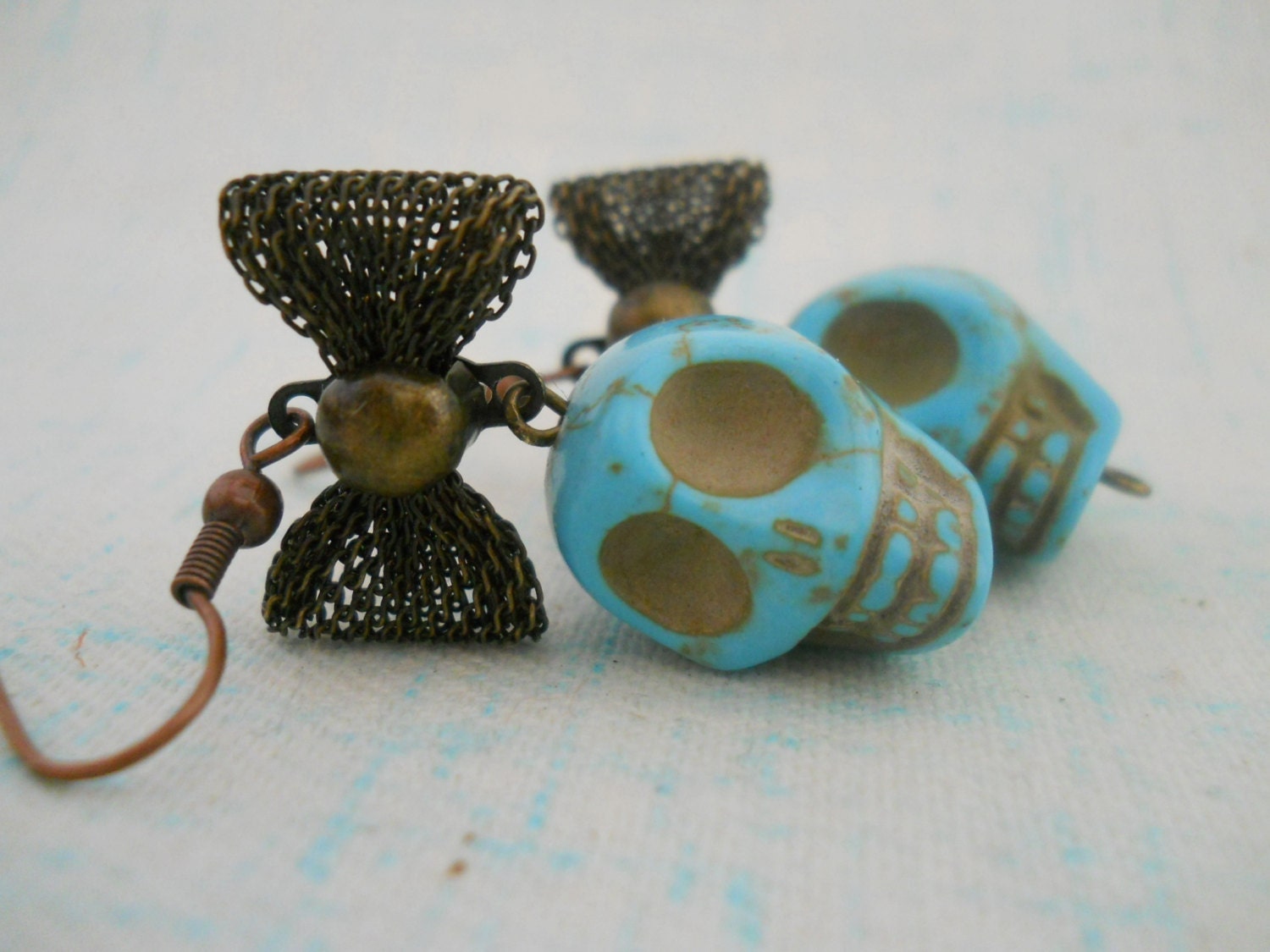 Turquoise skull and bronze mesh bow earrings