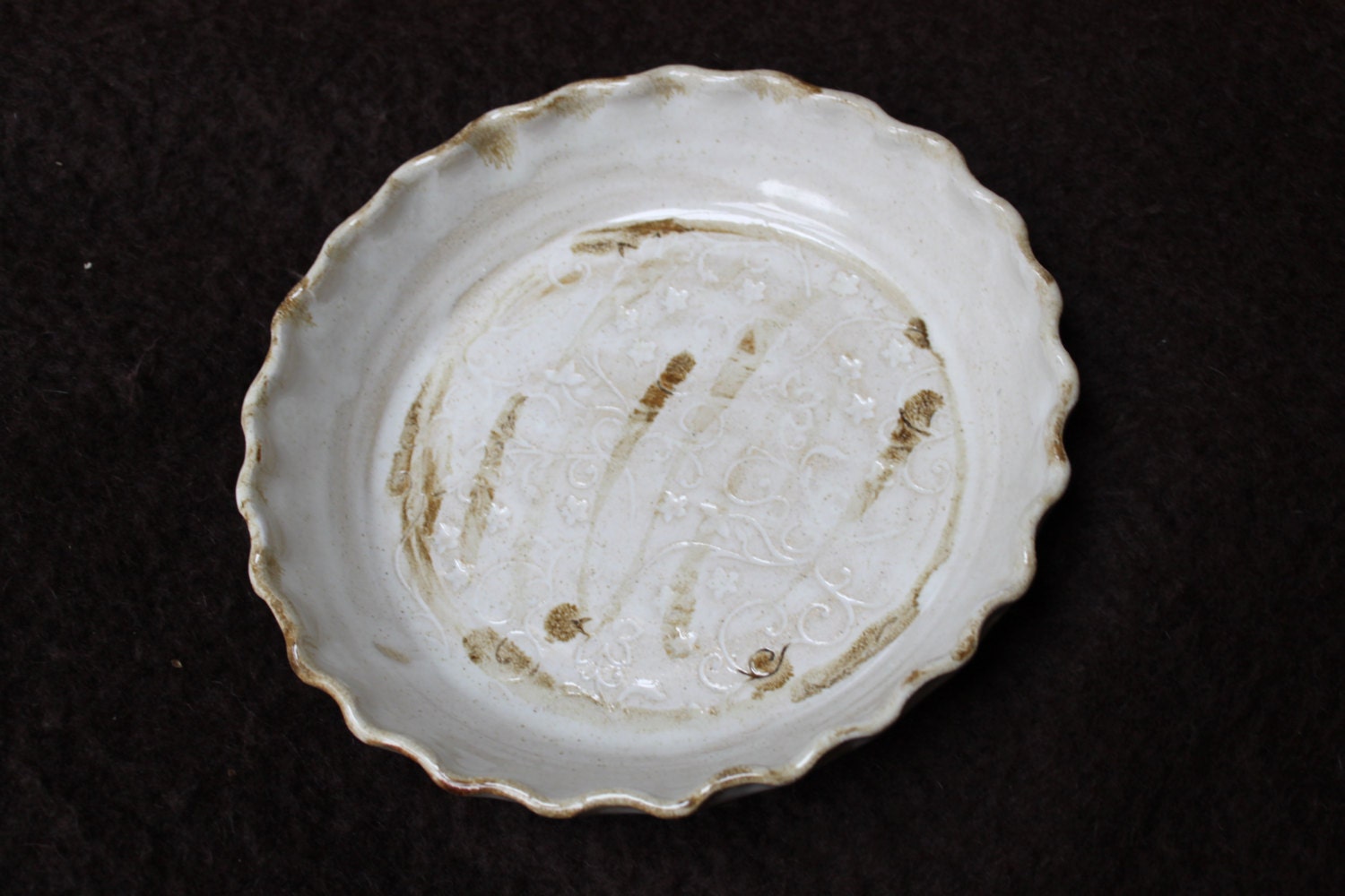 Handmade stoneware 9" pie plate with fluted edge and floral motif in creamy white and sand brown