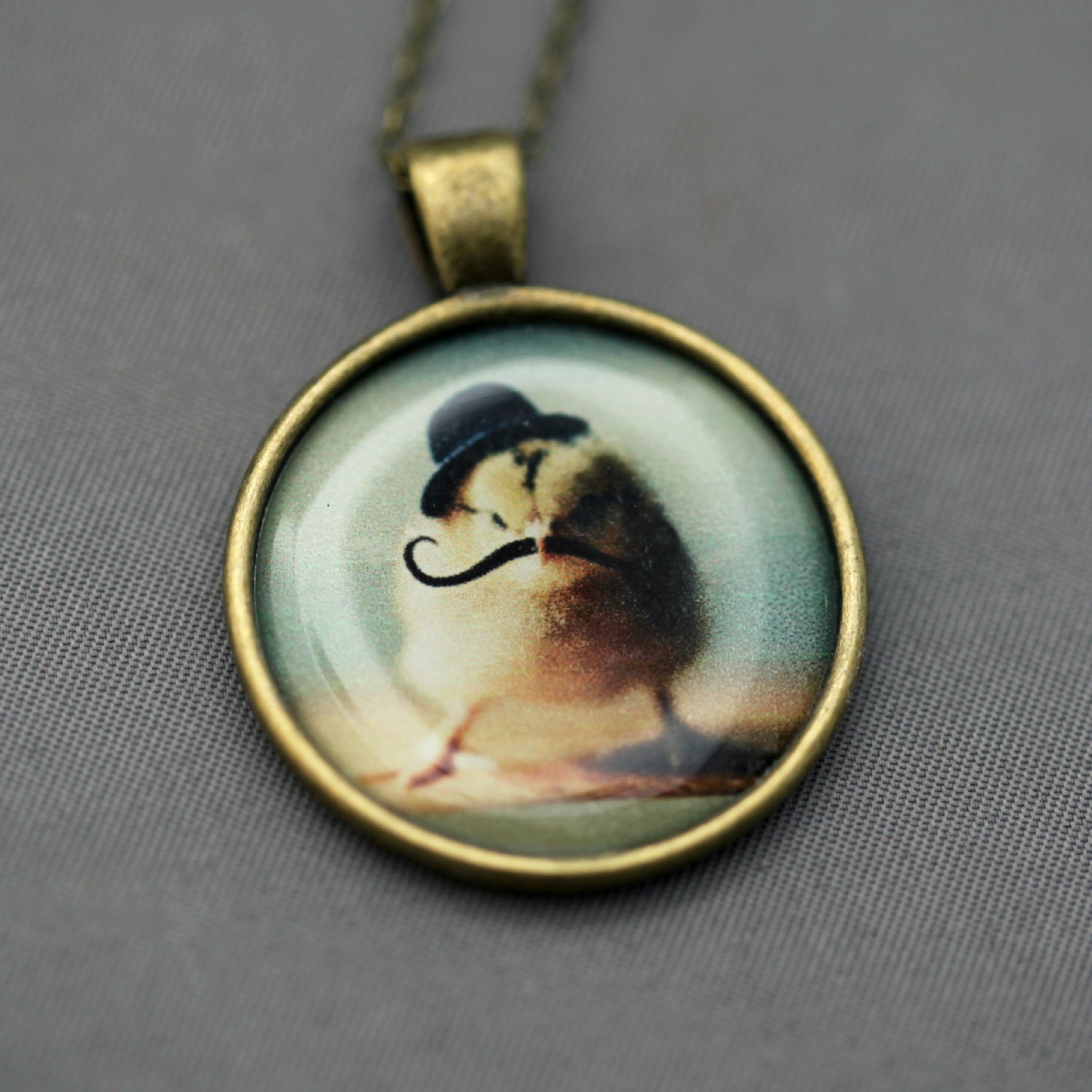 Photo Pendant Necklace of A Chick Wearing a Tiny Black Bowler Hat and Mustache