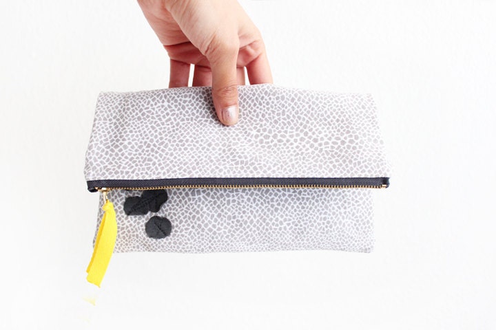 Grey and white geometric print with magenta fold over clutch