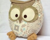 Chubby owl pillow in shades of neutral beige with touches of blue.