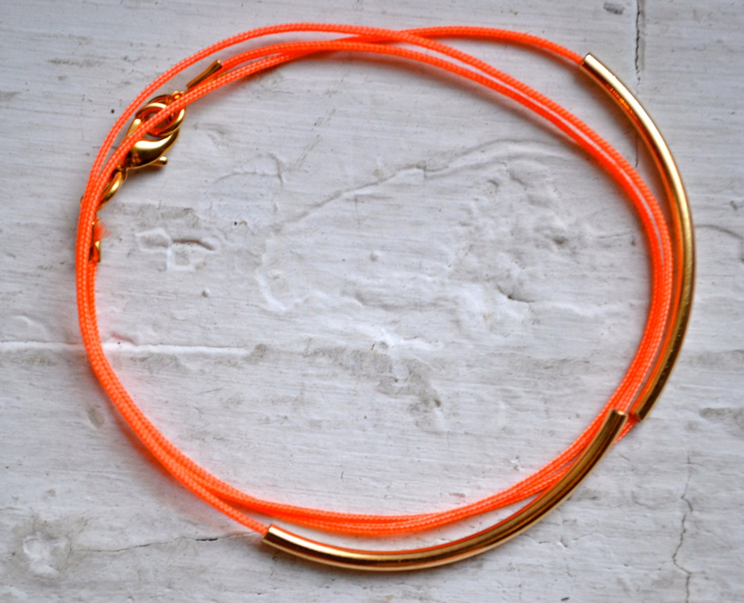 neon orange super skinny nylon triple wrap bracelet with two long gold tube