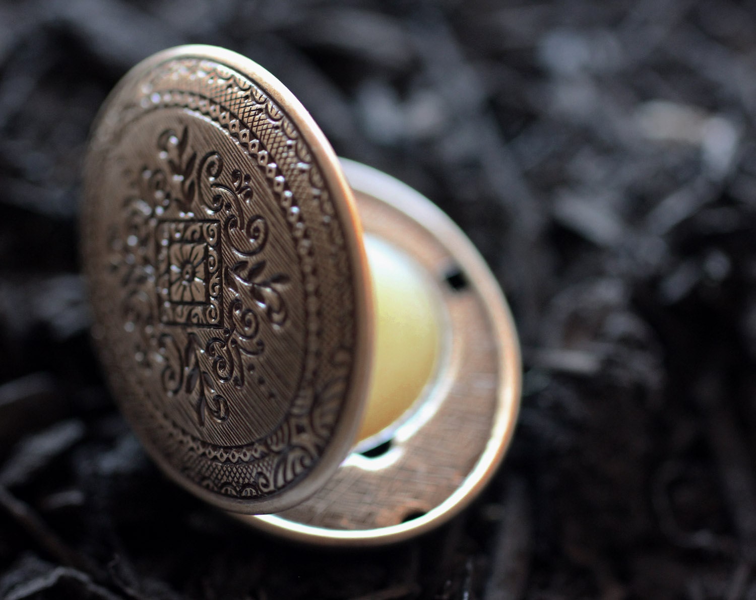 Figure 1: Noir Solid, Natural Perfume Mini Compact Locket - A wet mossy earthiness that comes from a braid of leaves, roots and woods.