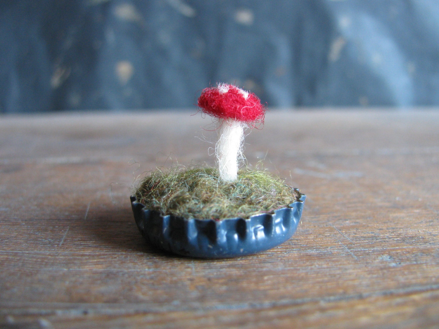 Felted amanita mushroom in a medium blue bottlecap
