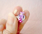 Tiny Cheshire Cat in a miniature tea cup