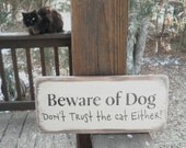 funny pet sign "beware of dog, don't trust the cat either" made of wood. humorous sign