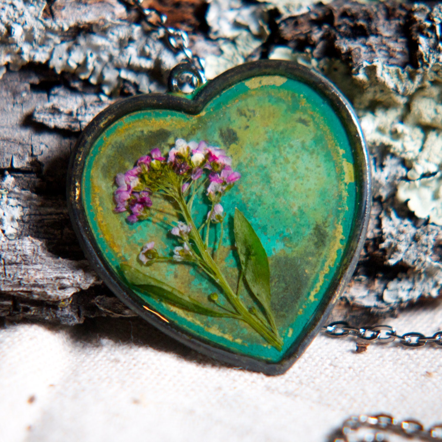 dried flower real pressed flower botanical necklace. heart verdigris patina pendent. pink wildflower.